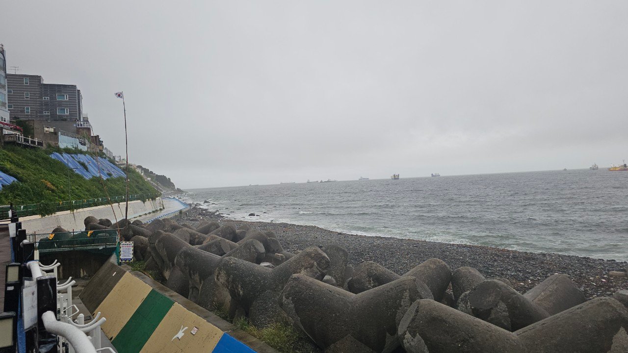Cargo ships anchored offshore in stormy weather off the coast of Busan