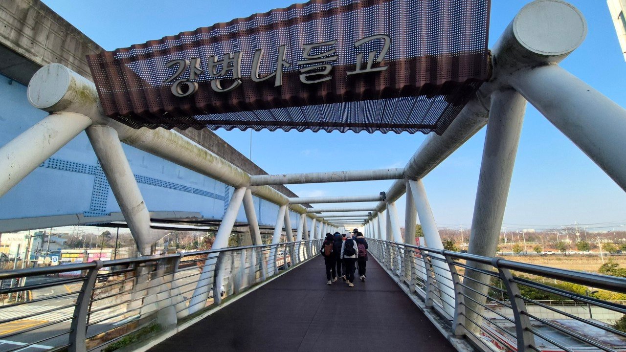Pedestrian overpass bridge named Gangbyeon Nadeulgyo near Renecity Station, Busan, with walkers crossing