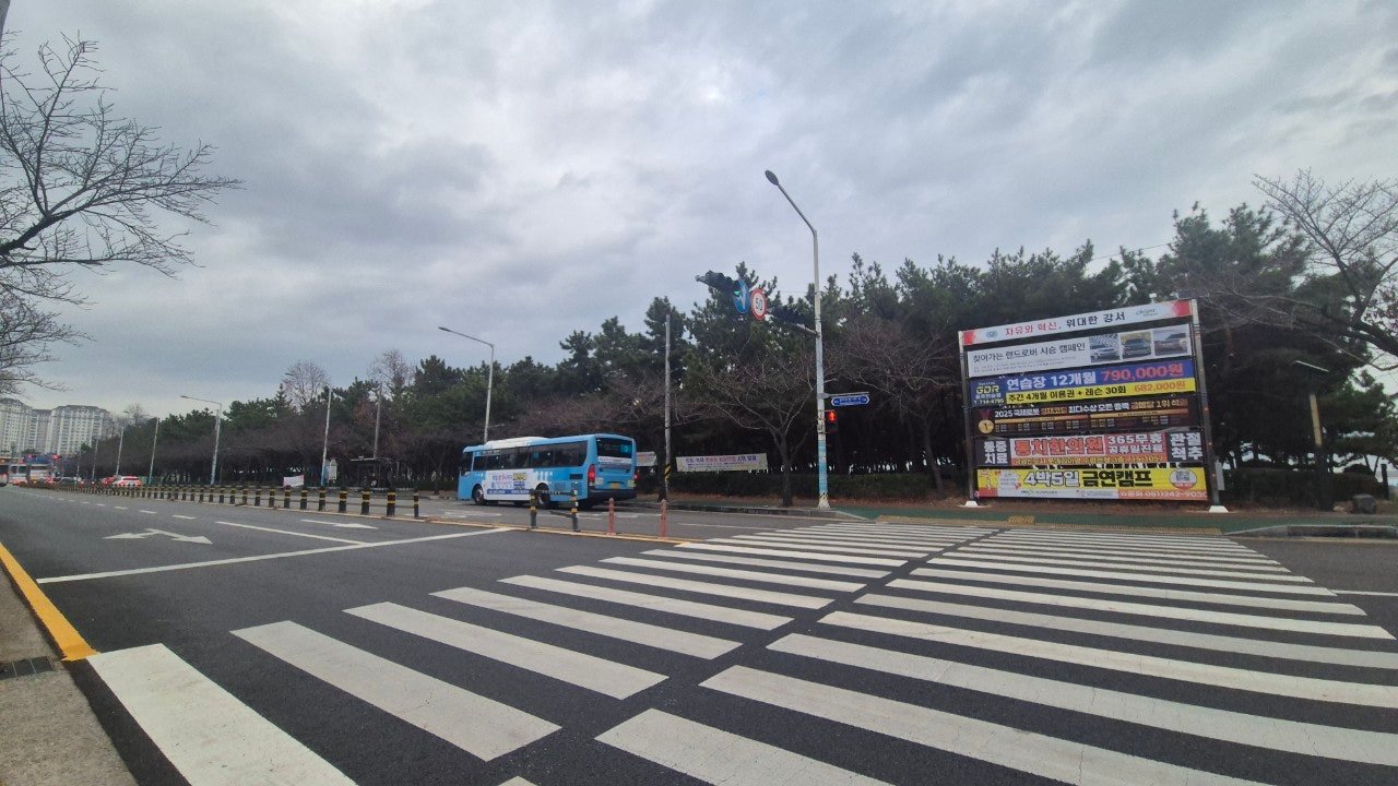 Crosswalk and bus on a cloudy day in Gangseo district, Busan, near the start of Gamnaetgil Course 14
