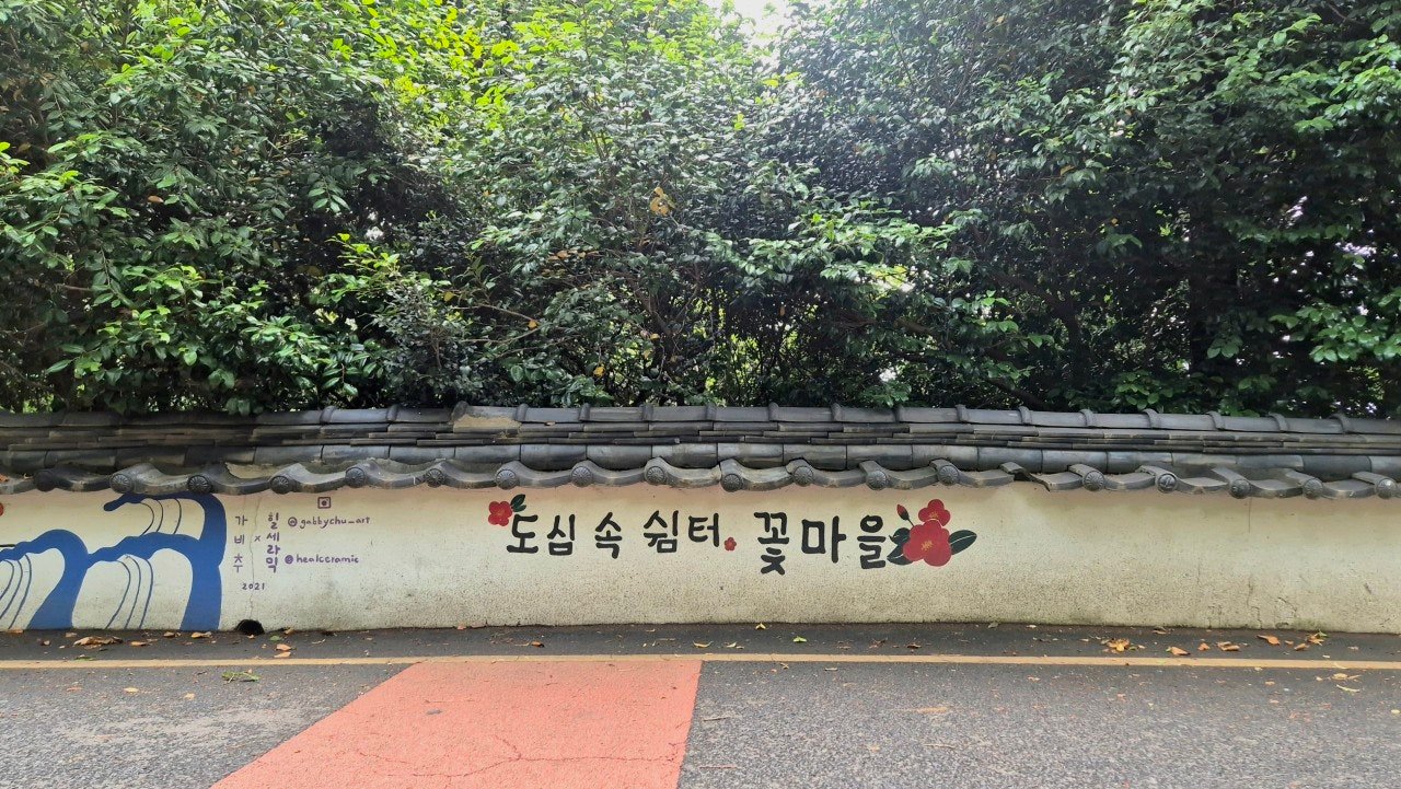 Tiled wall mural reading Kkotmaeul (Flower Village) rest stop in the city, near Guduk Cultural Park, Busan