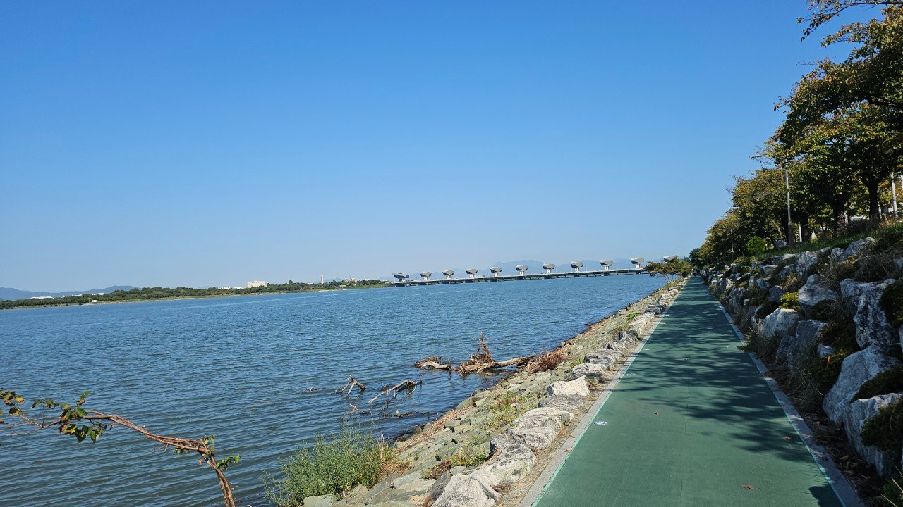 Paved riverside bike and walking path along the Nakdong River near the estuary bank, Busan, on a clear autumn day